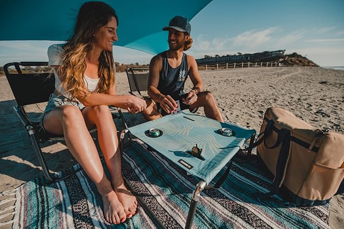 Neso Beach Table - Lightweight Portable and Foldable Table for Beach Camping and Outdoor Adventures - Stable Surface - with Cup Holder for Drinks and Phone Pockets - Aqua Fronds